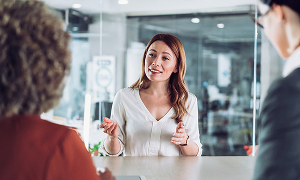 Nurse job interviews: woman talks to interview panellists who sit opposite