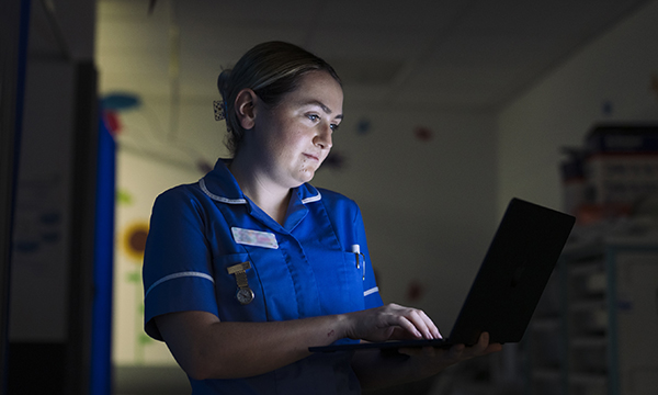 A nurse at a hospital work station working late into the night