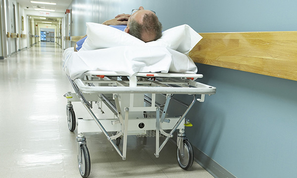 Corridor care crisis: patient on bed in hospital corridor