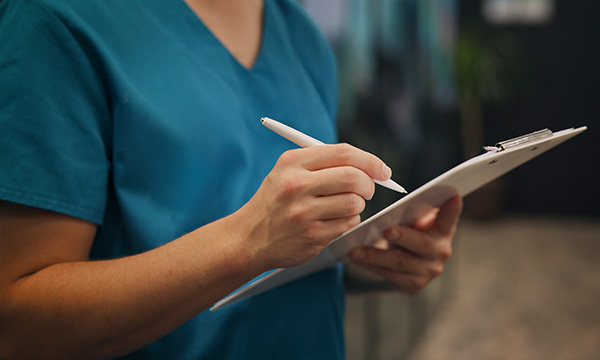 Nurse suspended: nurse writing notes on a clipboard