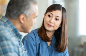 Active listening in nursing: nurse sitting with a service user, making eye contact as he talks