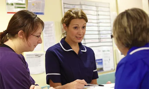 Rise in numbers of senior nurses; a senior nurse explains something to two colleagues